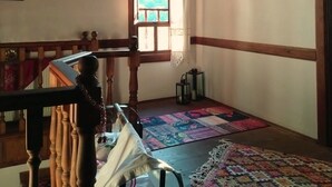 A room with a wooden ceiling, a window with curtains, a patterned rug, and a bed with a white cover. - Ahşena Bağ Badeli Konak Safranbolu (Safranbolu)