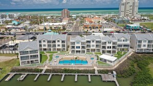 A coastal hotel with multiple buildings, a swimming pool, and a marina. - Bay Front: Gradual-Entry Pool: Boat Slip (South Padre Island)