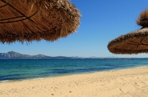 Ranta lähistöllä, aurinkotuoleja, rantapyyhkeitä