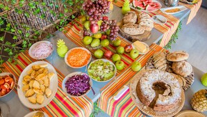 Une table de buffet proposant une variété d’aliments, notamment des fruits, des légumes et du pain.