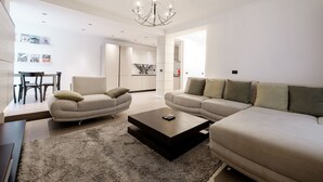 A modern living room with a sofa set, a coffee table, and a chandelier. - Boutique Hotel Whisky (Tirana)