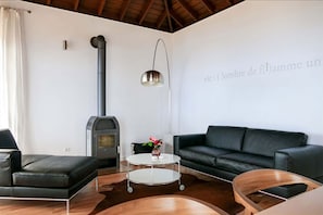 Un salon moderne avec un canapé, une table basse, une cheminée et une lampe fixée au mur.