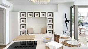 Una cocina moderna con una isla central, una estantería empotrada y un comedor con vistas.