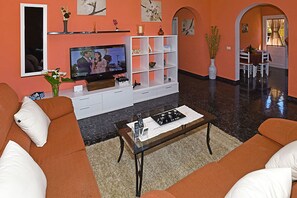 A living room with a television, sofa, coffee table, and a white entertainment unit. - Villa La Hoya en Tijarafe (Tijarafe)