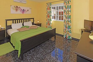 A bedroom with a bed, nightstands, a window with curtains, and a television. - Villa La Hoya en Tijarafe (Tijarafe)