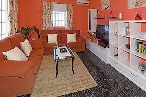 A living room with a sofa, coffee table, TV, and a bookshelf. - Villa La Hoya en Tijarafe (Tijarafe)