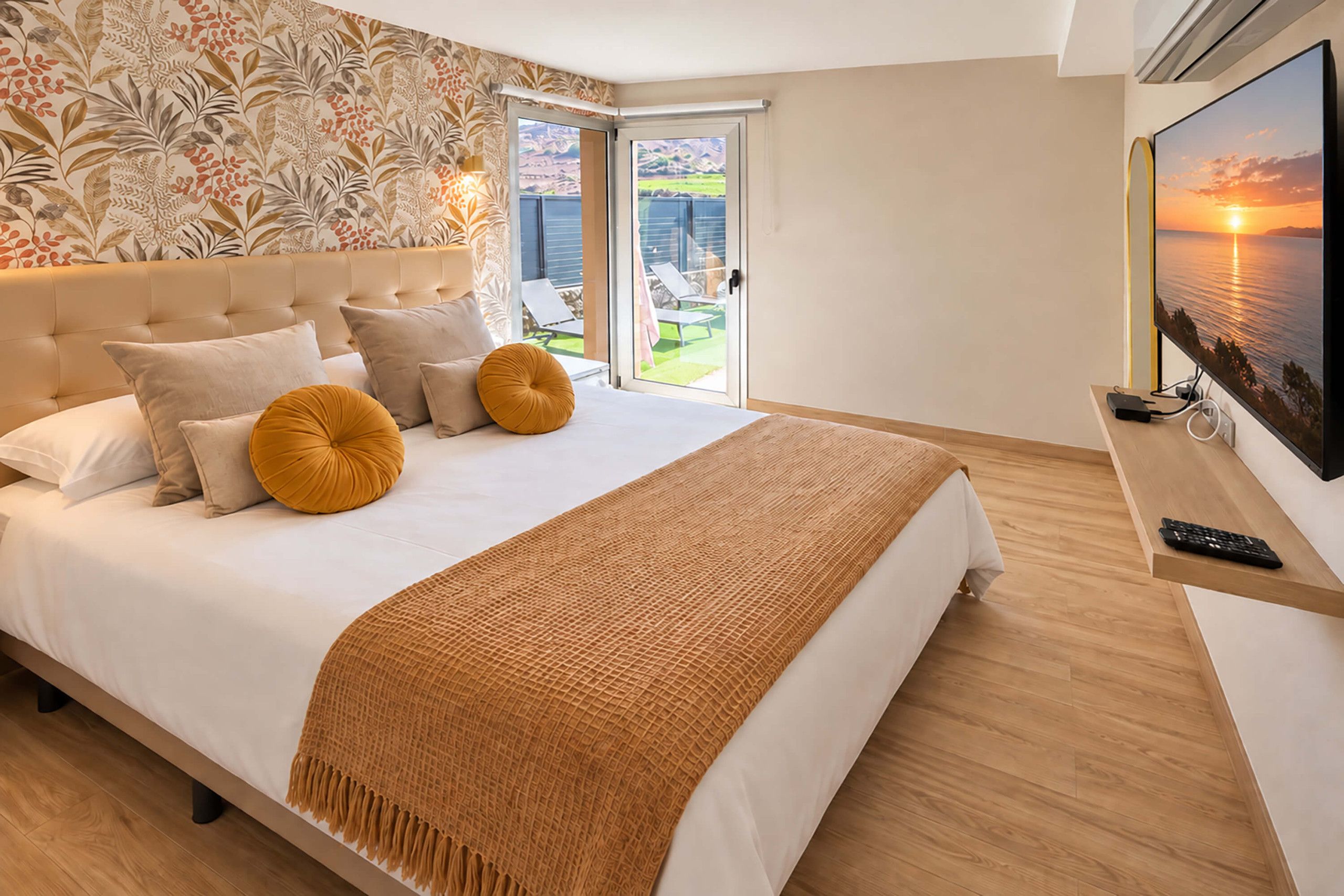 A modern bedroom with a large bed, a view of the outdoors, and a painting on the wall.