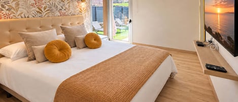 Ein modernes Schlafzimmer mit einem großen Bett, Blick ins Freie und einem Gemälde an der Wand.