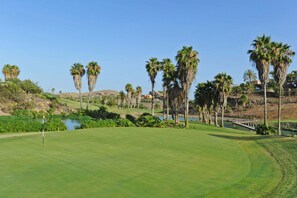 A golf course with a pond, palm trees, and a bridge. - Villa Salobre Par 4 N° 22 (Maspalomas)