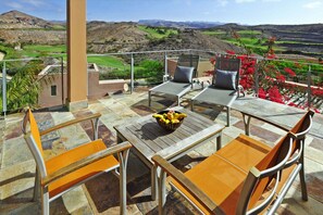 Eine Terrasse mit Tisch, Stühlen und einer Obstschale.