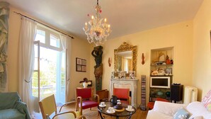 Una sala de estar con chimenea, candelabro y televisor.