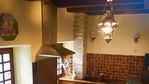 Una cocina con armarios de madera, estufa y salpicadero de azulejos.
