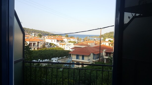 A balcony with a view of a coastal town, featuring houses with red-tiled roofs and a clear sky. - Apartment with a view (Palaia Epidavros)