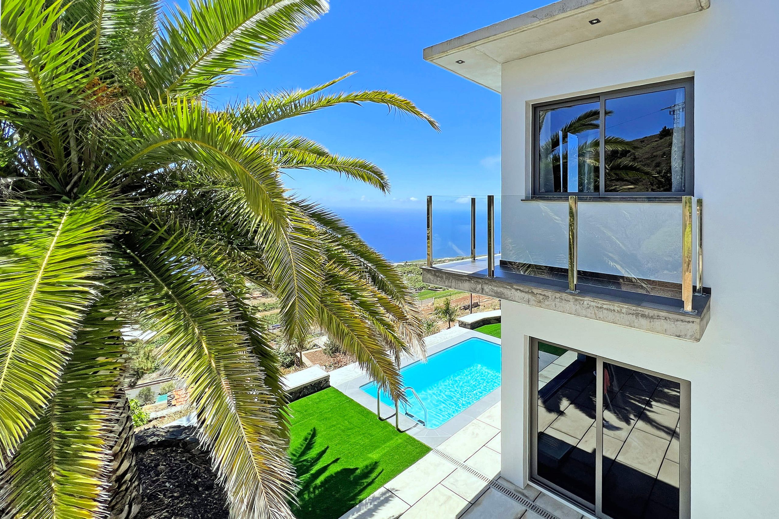 Un bâtiment moderne à deux étages, doté d’une piscine et offrant une vue sur l’océan.