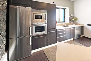 A modern kitchen with stainless steel appliances, a built-in oven, and a window above the sink. - Villa Gamonal en Tijarafe (Tijarafe)