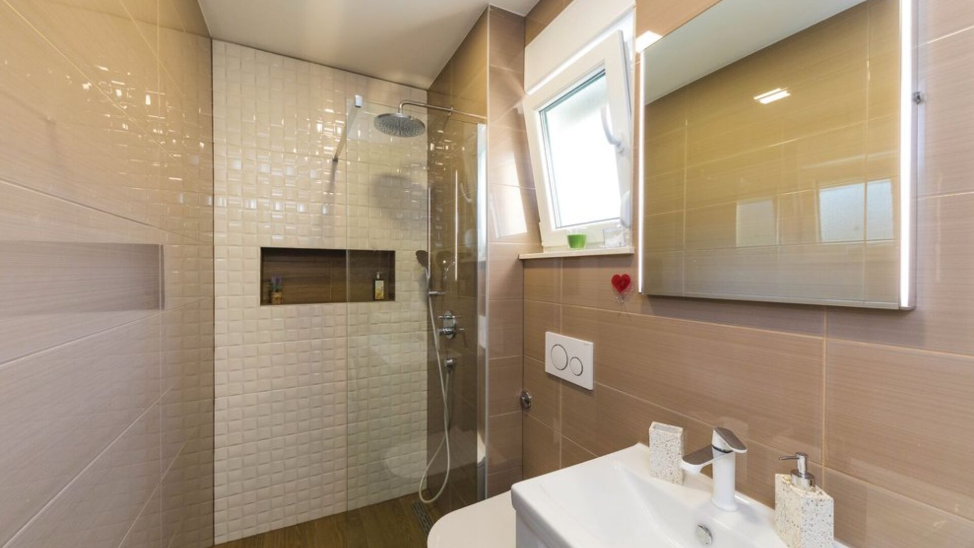 Een moderne badkamer met een douchecabine van glas, een wastafelmeubel met spiegel en een klein raam.