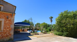 A courtyard with a pool, outdoor seating, and a covered area. - Can Palea 407 finca with private pool with garden, terrace, barbecue and WiFi (Campos)