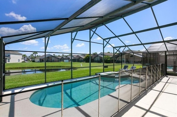 Una piscina esterna coperta con vista su un quartiere residenziale.