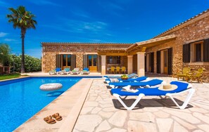 A poolside area with lounge chairs and a stone building. - Can Mates Nou 404 fantastic finca with private pool, terrace, ping pong and air conditioning. (Campos)