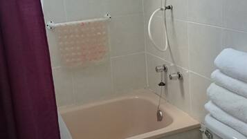 A bathroom with a bathtub, toilet, and shower.
