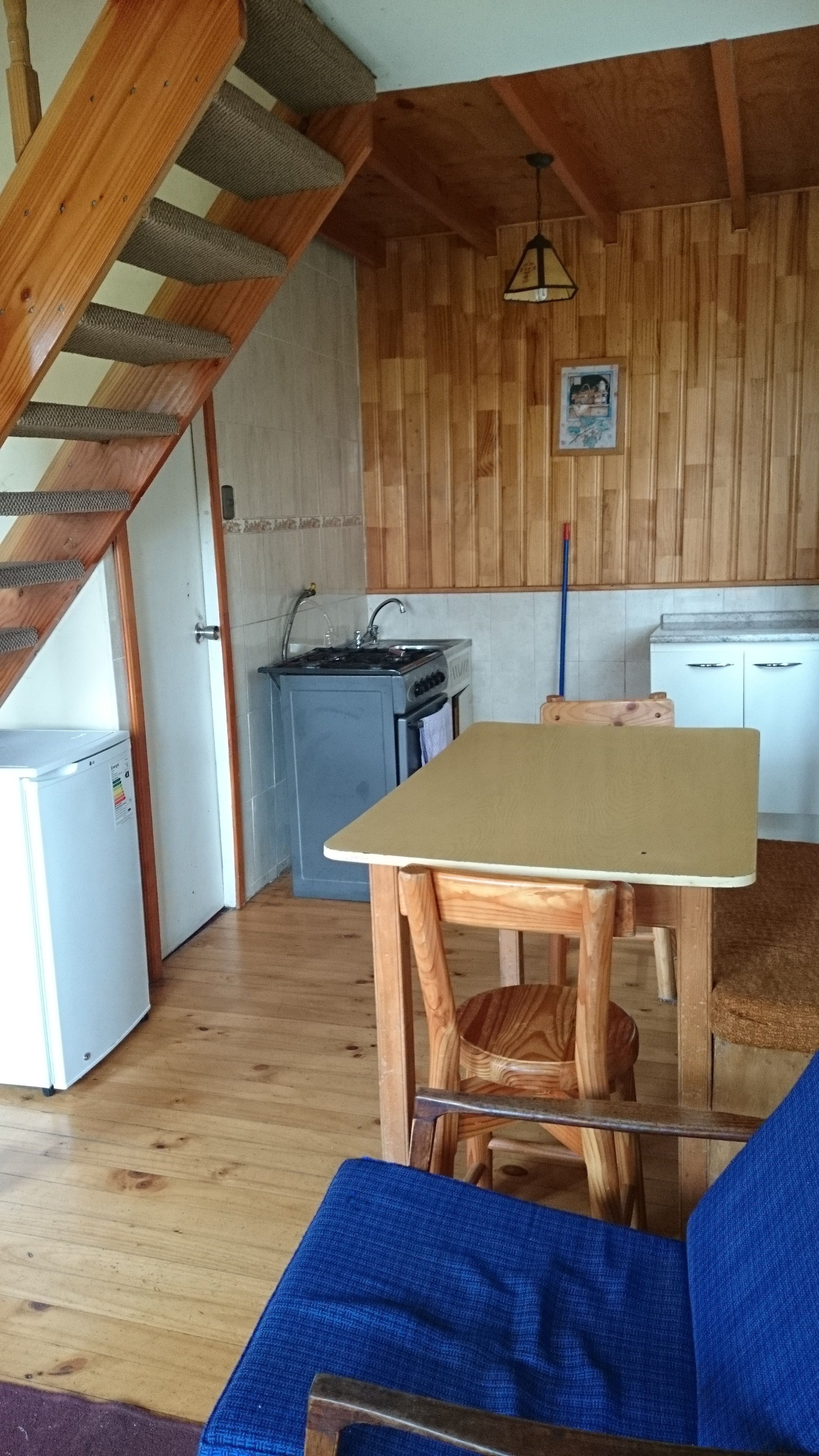 A kitchen with wooden walls, a stove, and a sink.