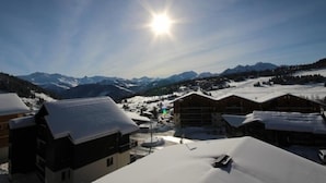 A snow-covered mountain village with traditional wooden buildings and a clear view of the surrounding peaks. - Cozy apartment in Les Saisies - 6 pers, fireplace, south balcony (Les Saisies)