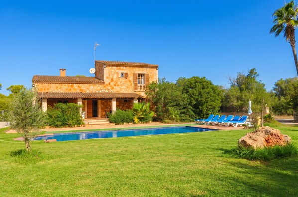 A two-story house with a swimming pool and a patio with lounge chairs. - Can Toni 403 traditional finca with private pool, air-conditioning, large garden and WiFi (Campos)