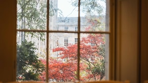 A room with a large window, a table, and chairs.