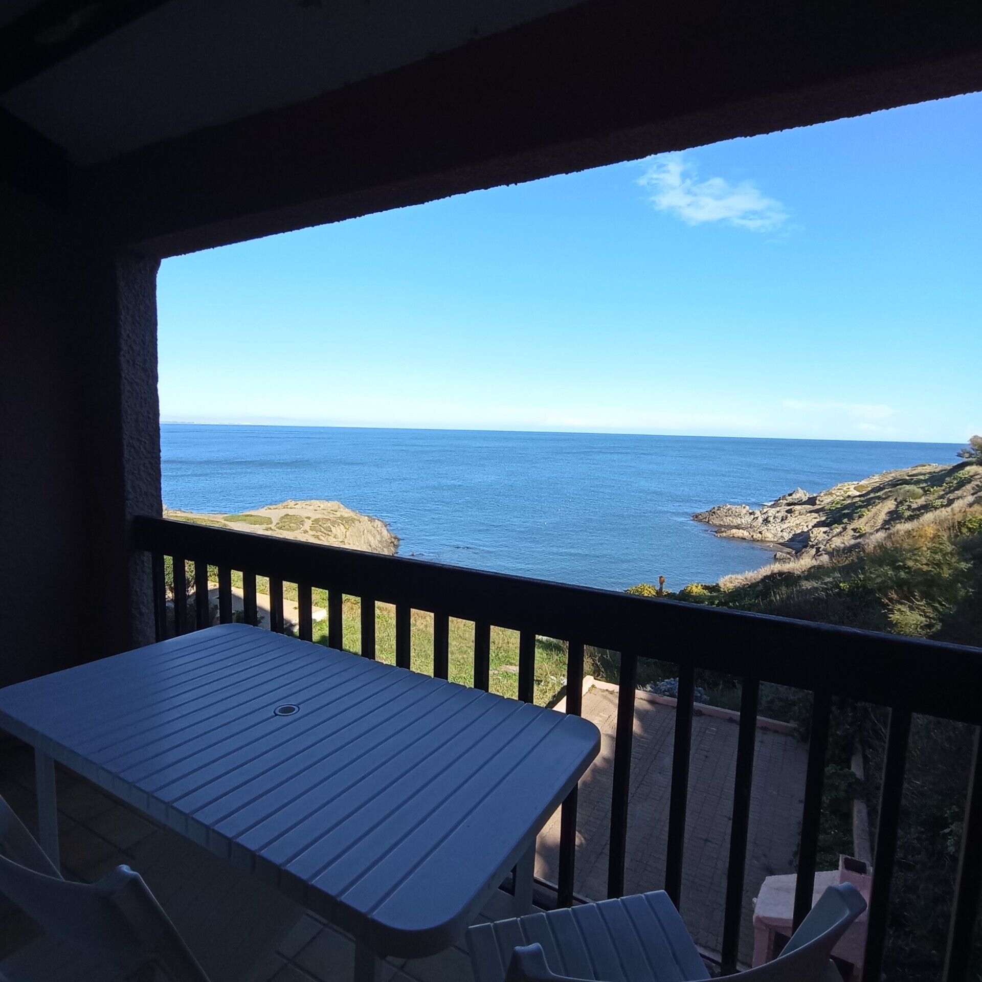Ein Balkon mit Blick auf das Meer und die felsige Küste.