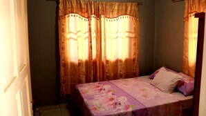 A bedroom with a bed, curtains, and an air conditioning unit. - Abidager 2  ideal for family with children and groups (Wanica)