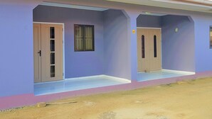 A building with two doors, each with a small window above. The building has a flat roof and a simple, unadorned facade. - Abidager 2  ideal for family with children and groups (Wanica)