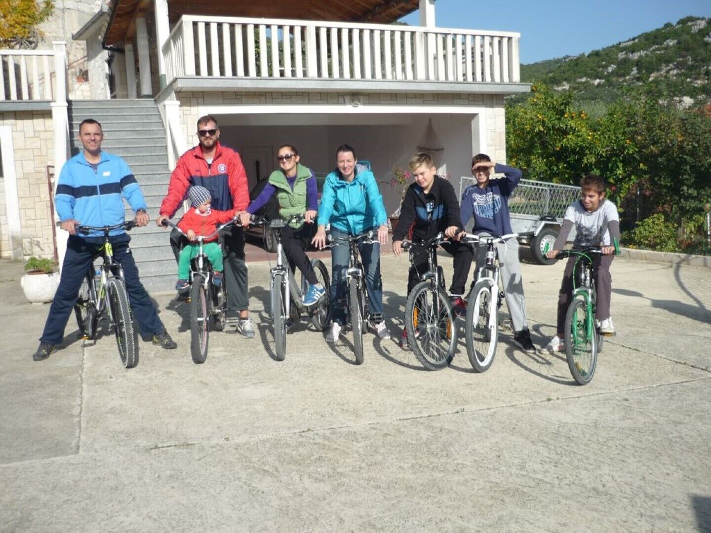Eine Gruppe von Radfahrern vor einem Gebäude mit einem Balkon.