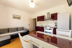 Una cocina moderna con una mesa de comedor, un sofá y un refrigerador.
