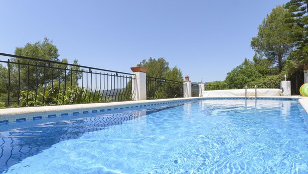 A clear swimming pool with a tiled edge, surrounded by a metal fence and greenery. - CASABRA - Villa with private pool in Urb. Monterrey, Palma de Gandia. Free WiFi (Palma de Gandia)