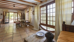 A room with wooden beams, a large window with curtains, a wooden table, and a bed. - CASABRA - Villa with private pool in Urb. Monterrey, Palma de Gandia. Free WiFi (Palma de Gandia)