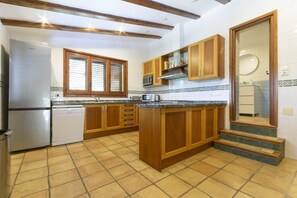A kitchen with wooden cabinets, a built-in microwave, and a dishwasher.