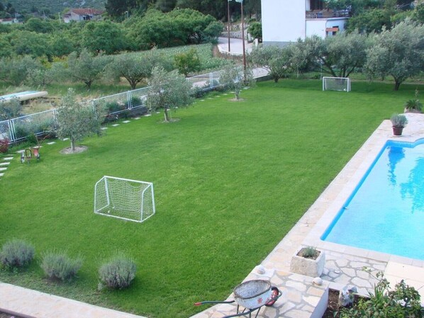 A backyard with a swimming pool, a soccer goal, and a small garden area with various plants. - FAMILY  APARTMENT MLADEN AT NATURE PARK CLOSE TO THE SEA (Peracko Blato/Ploce)