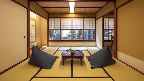 A traditional Japanese room with tatami flooring, a low wooden table with cushions, and shoji screens. - Utaimachi (Kanazawa)