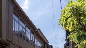 A narrow alleyway between traditional wooden buildings with a clear sky above. - Utaimachi (Kanazawa)