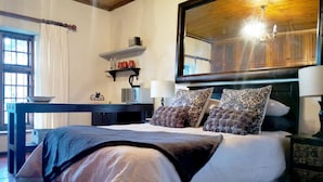 Una camera da letto con un letto grande, un comodino, uno specchio e una finestra.