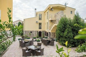 A building with a stone facade, multiple windows, and a balcony. - Hotel Crnogorska Kuca (Podgorica)