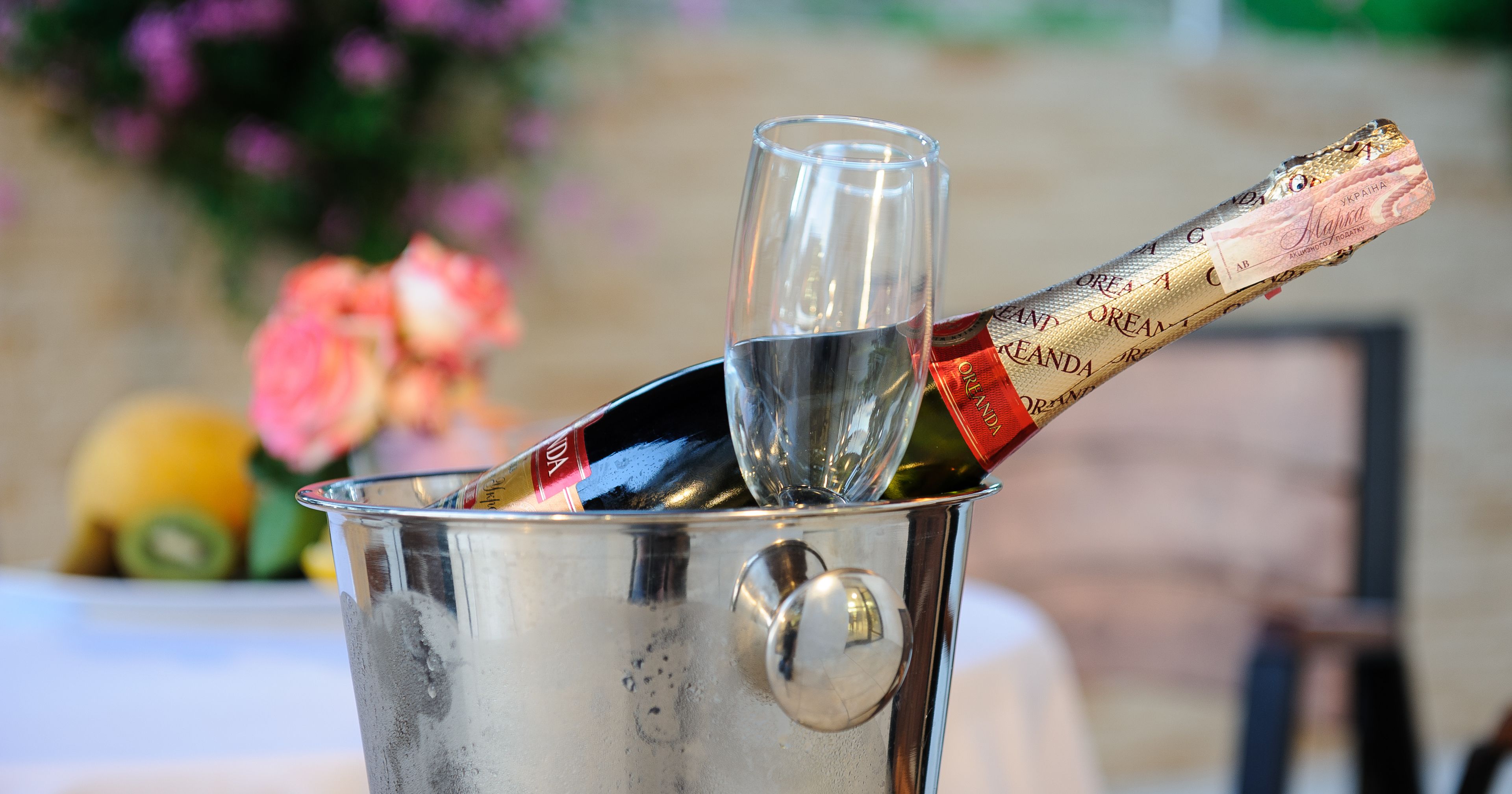 Une bouteille de champagne dans un seau en métal avec un verre.