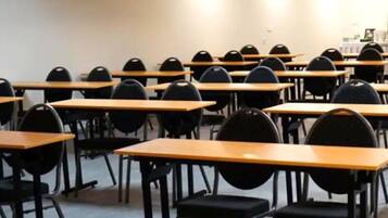 Et klasseværelse med rækker af borde og stole, indrettet i en traditionel klasseværelsesopstilling.