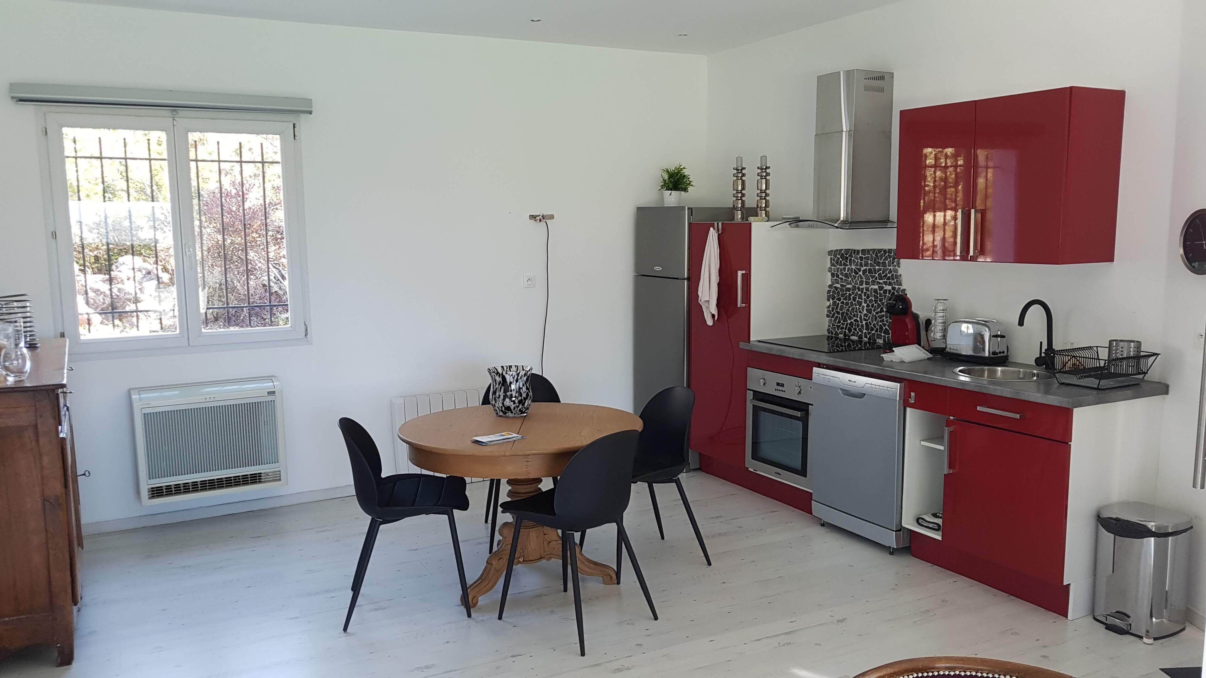 Una cocina compacta con comedor, que incluye estufa, horno y refrigerador.