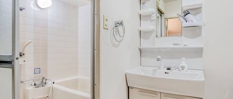 A bathroom with a bathtub, a sink, and a mirror.