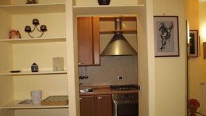 A modern kitchen with wooden cabinets, a stainless steel range hood, and a built-in oven. - Casa Pierosa: pretty, private and welcoming (Frosinone)