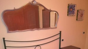 A bedroom with a bed, a nightstand, a dresser, a mirror, and two wall decorations. - Casa Pierosa: pretty, private and welcoming (Frosinone)
