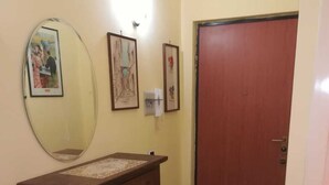 A hallway with a wooden counter, a mirror, framed pictures, a door, and a tiled floor. - Casa Pierosa: pretty, private and welcoming (Frosinone)