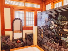 Um quarto japonês tradicional com tatames, um painel shoji, um espelho e um pergaminho de caligrafia.