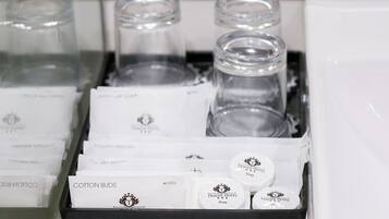 A tray with various toiletries including cotton buds, toothbrushes, and soap from Prague Hotel.